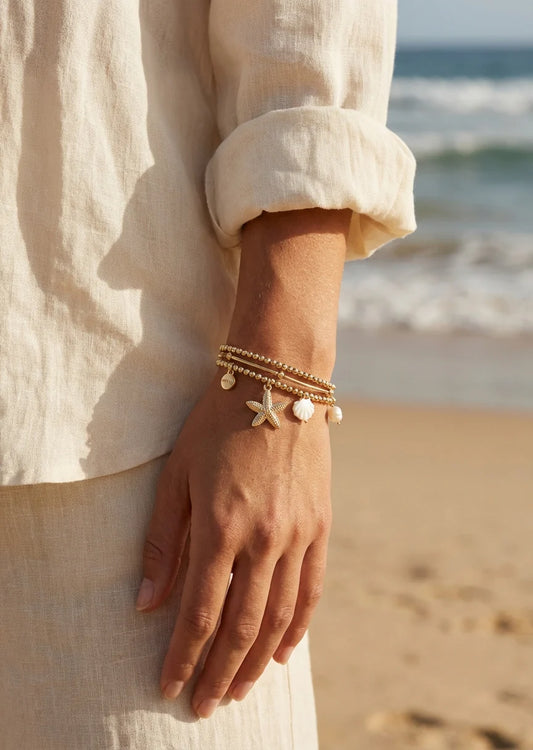 Gold triple layered stretch bracelet with starfish and pearl charms